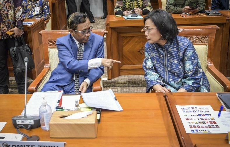 Menkopolhukam sekaligus Ketua Komite TPPU Mahfud MD (kiri) berbincang dengan Menkeu Sri Mulyani saat mengikuti rapat dengar pendapat bersama Komisi III DPR di Kompleks Parlemen, Senayan, Jakarta, Selasa (11/4/2023). (ant)
